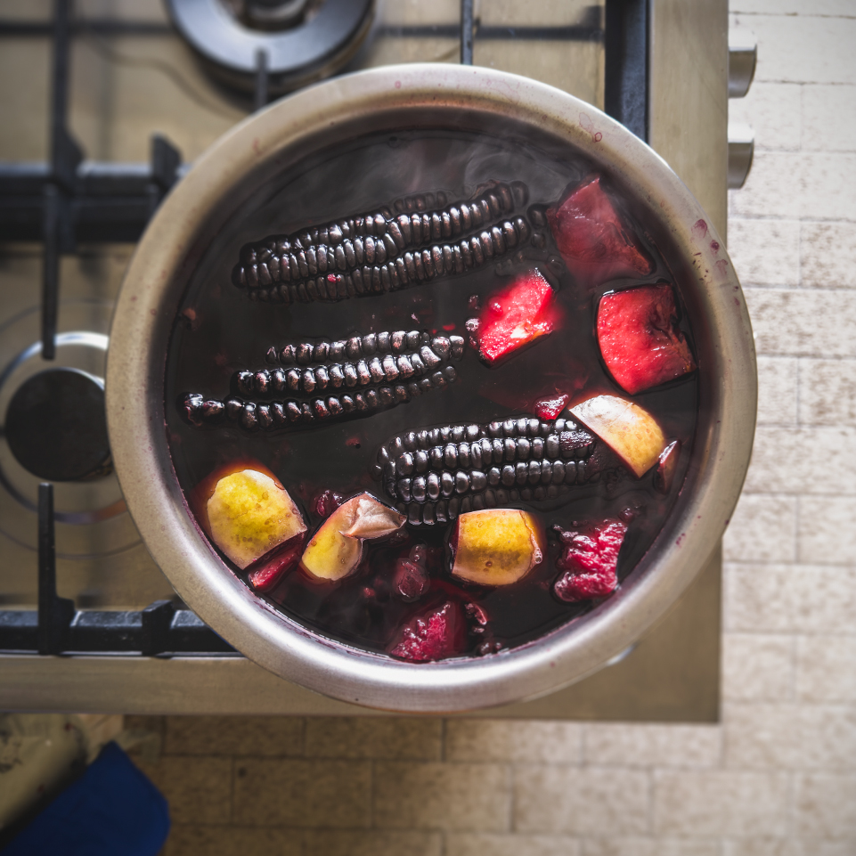 Chicha Morada boiling in pot purple corn apples pineapple peel